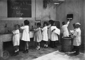 Antes de sentarse a la mesa los niños se lavan las manos utilizando para secarsetoallas de papel como medida de higiene. Noviembre de 1921.documento Fotográfico. Inventario 14072. Archivo General de la Nación