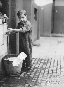Niño lavándose las manos en un conventillo de La Boca, 1930