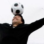 FILE PHOTO:  Former soccer star Maradona balances a soccer ball on his head during a photocall at the 61st Cannes Film Festival